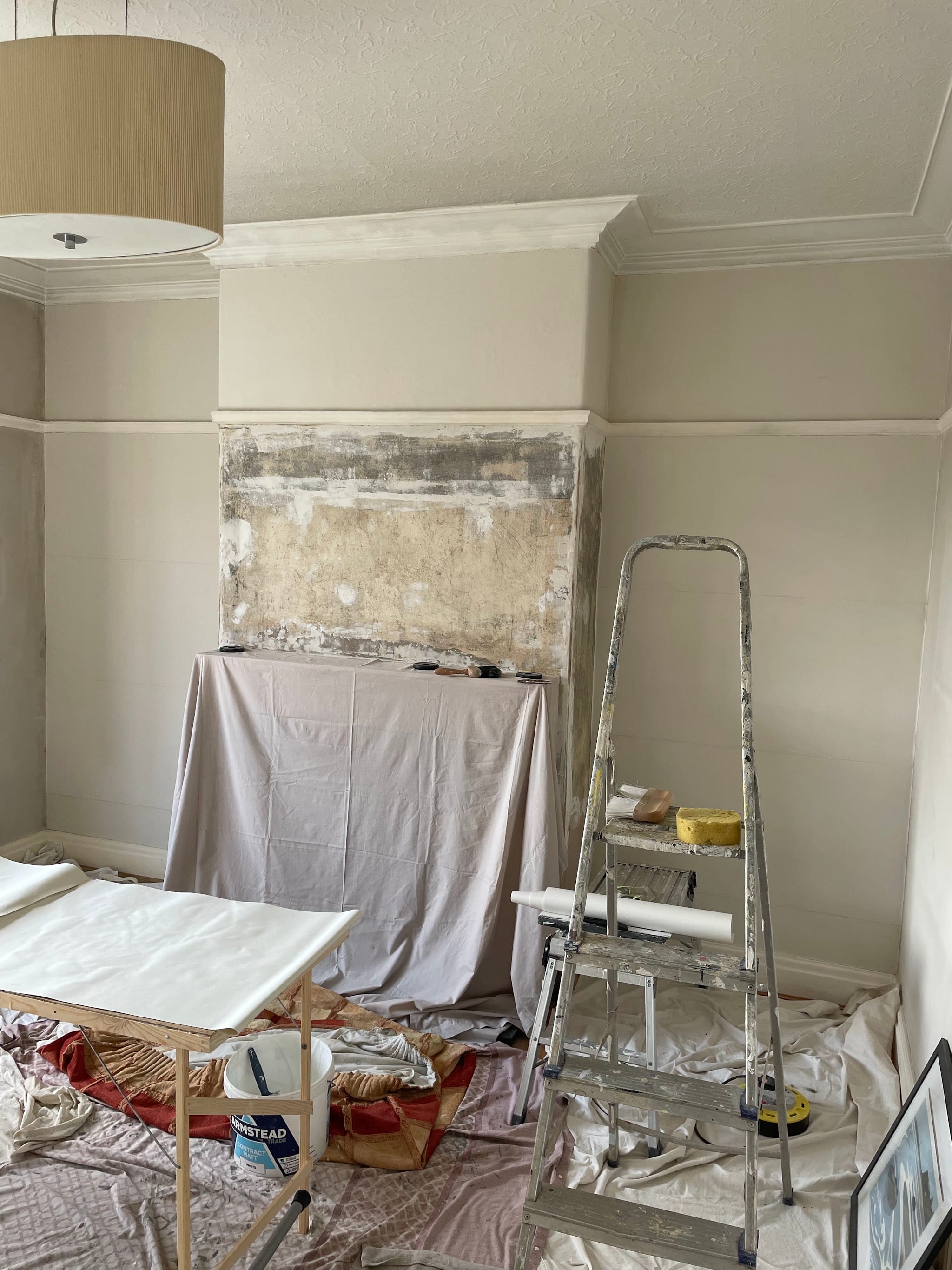 A room being prepared for decorating, with furniture protected