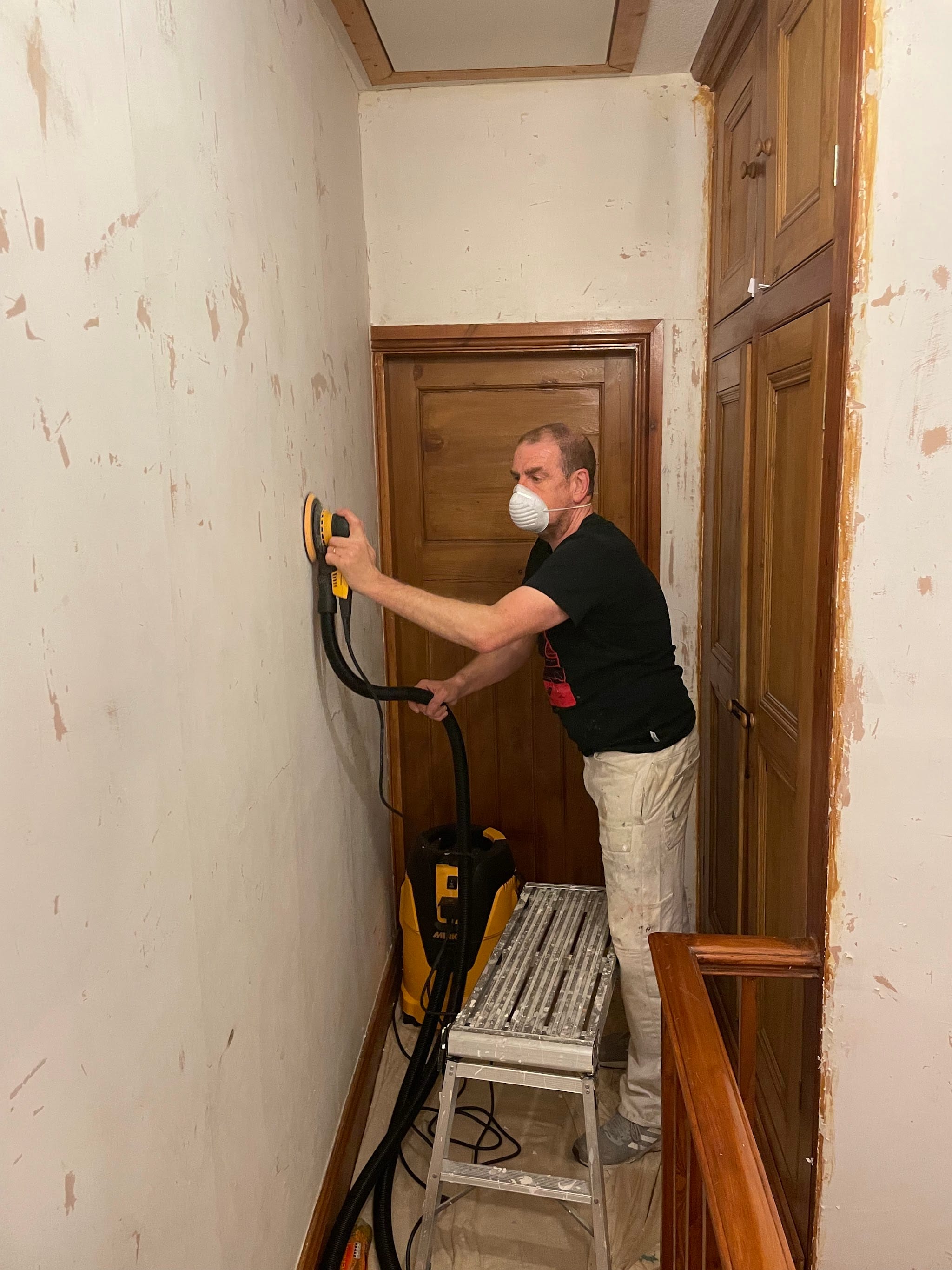 A decorator working beside a timber door